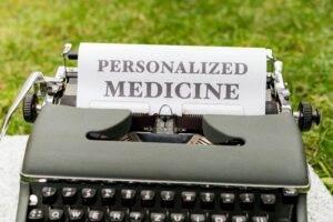 A typing machine with a sheet tucked into it. The sheet reads “Personalized Medicine”.